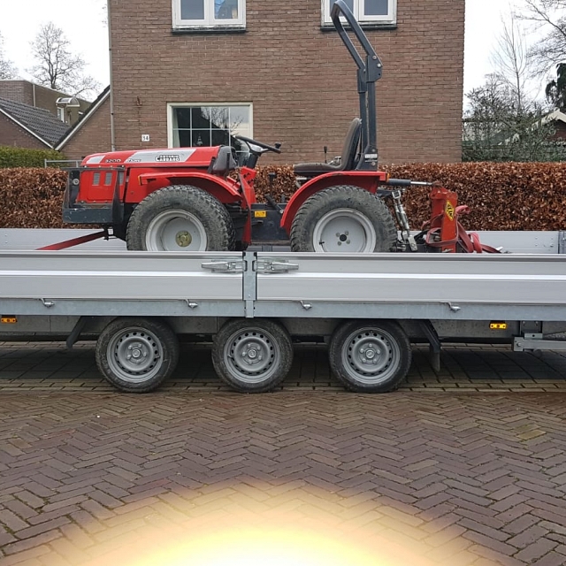 Tractor op de aanhanger, klaar voor transport naar het werk